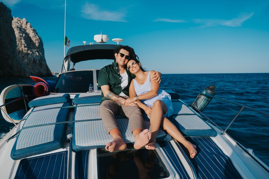 Happy couple enjoying a relaxing day on a yacht under clear blue skies in the Mediterranean Sea.